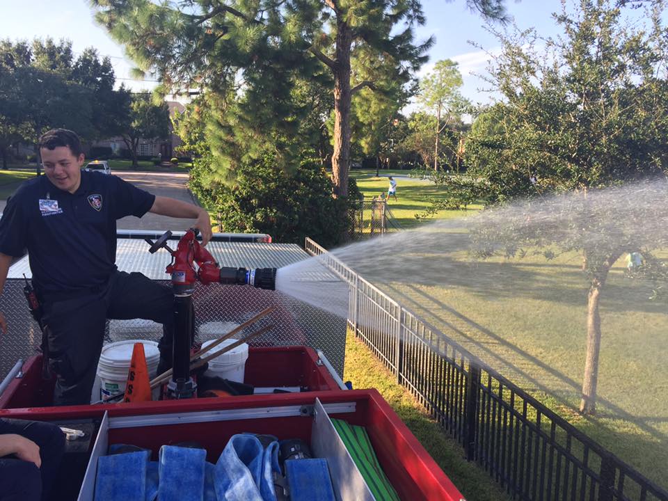 Fireman aiming the water hose from the top of the truck